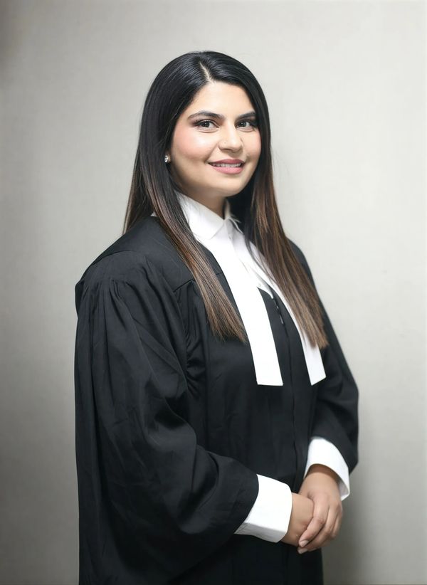 Confident woman in formal legal attire smiling gently.