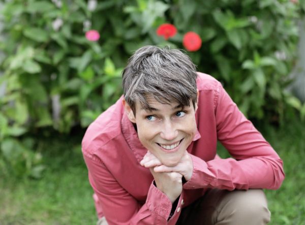 Person smiling while crouching outdoors.