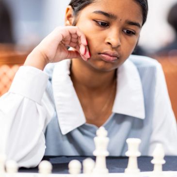 Girl deep in thought playing chess.