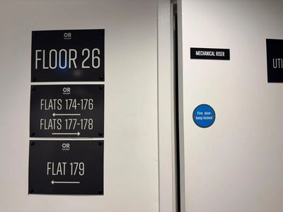 Signs indicating flats on floor 26 and a mechanical riser door.