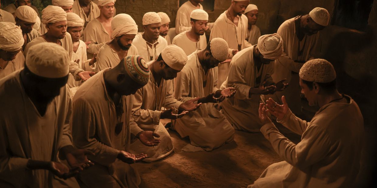 Group of men praying together indoors.