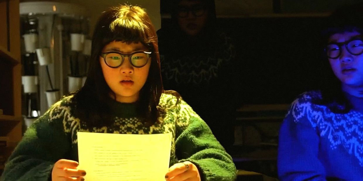 Person reading a paper under different colored lights.
