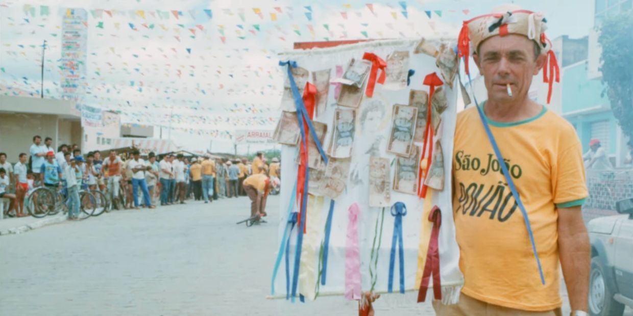 Man in yellow shirt with São João print at festival.