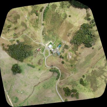 Aerial view of a rural area with scattered buildings and winding roads.