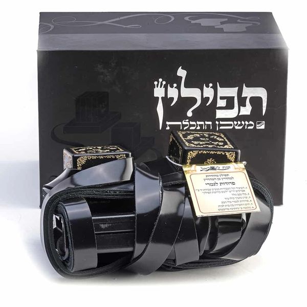 Black tefillin set with Hebrew inscriptions and packaging.