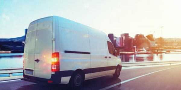 White transit van driving on highway