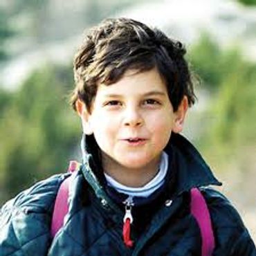 Young boy outdoors with a backpack.