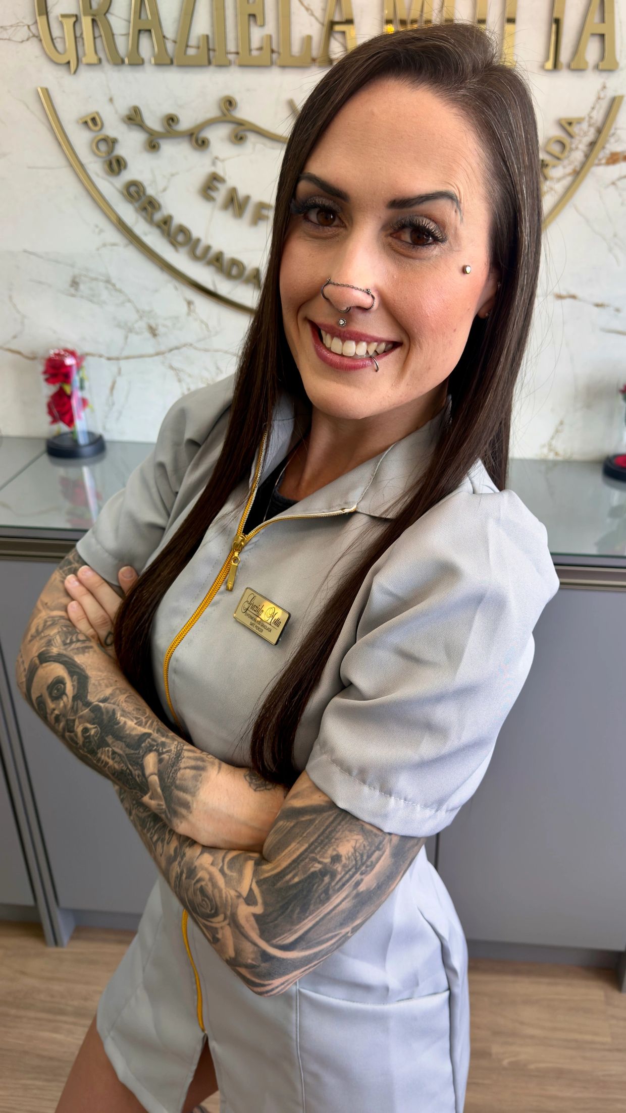 Smiling tattooed woman in professional uniform with piercings.