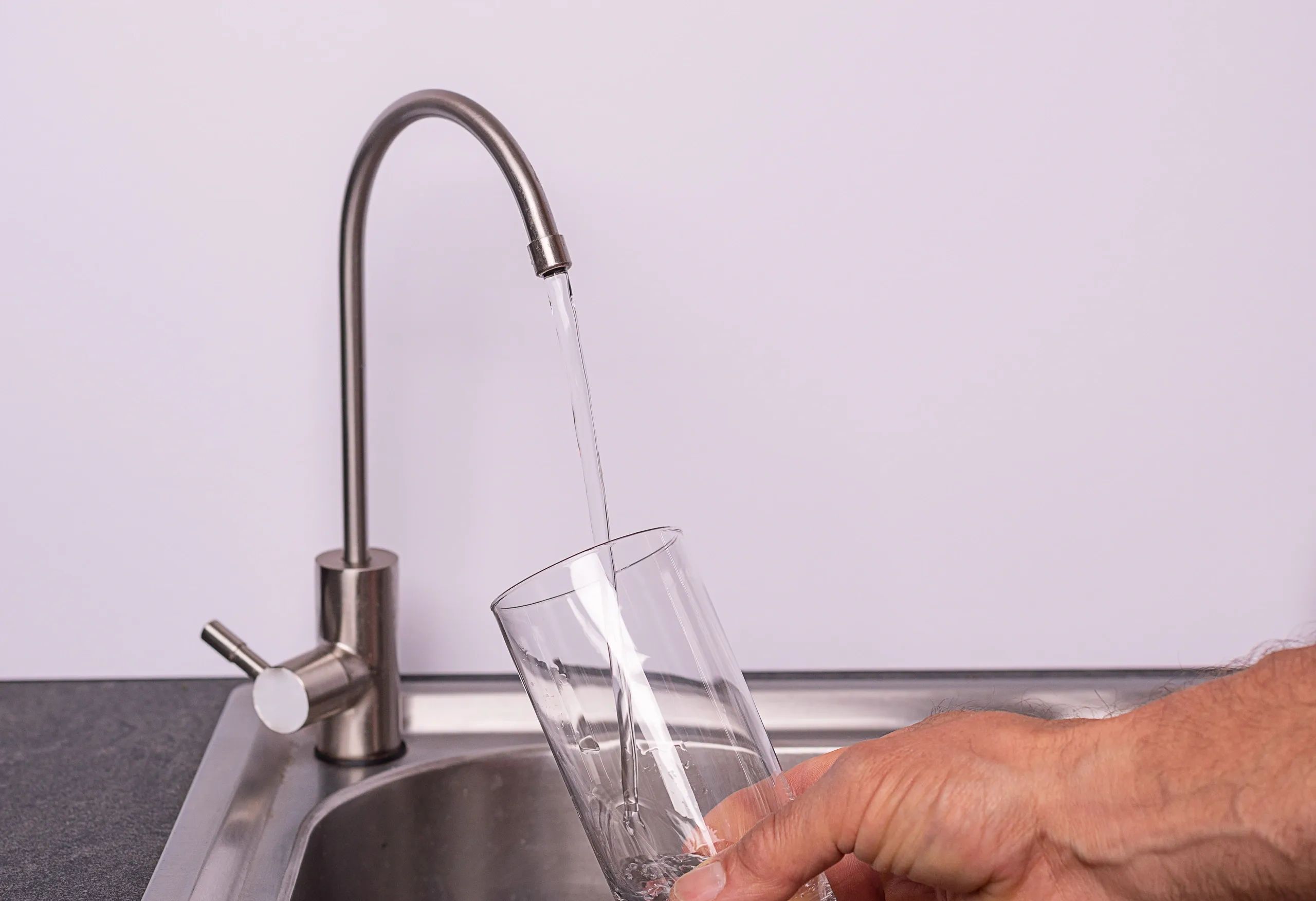 Sirviendo agua purificada en un vaso. Agua purificada por medio de osmosis inversa Glup Water
