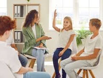 A teacher and children engaged in a group discussion.