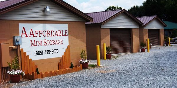 A.Affordable Mini Storage building with three closed storage units and gravel driveway.