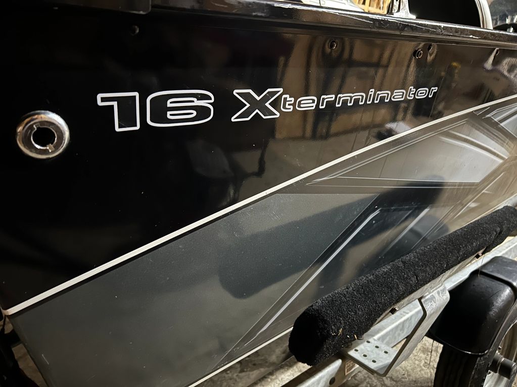 Close-up of a 16 Xterminator decal on a black surface.