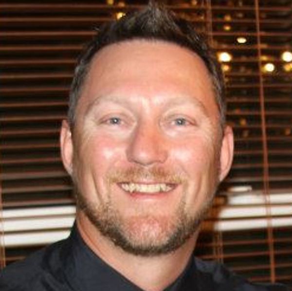 Smiling man with short hair and beard.