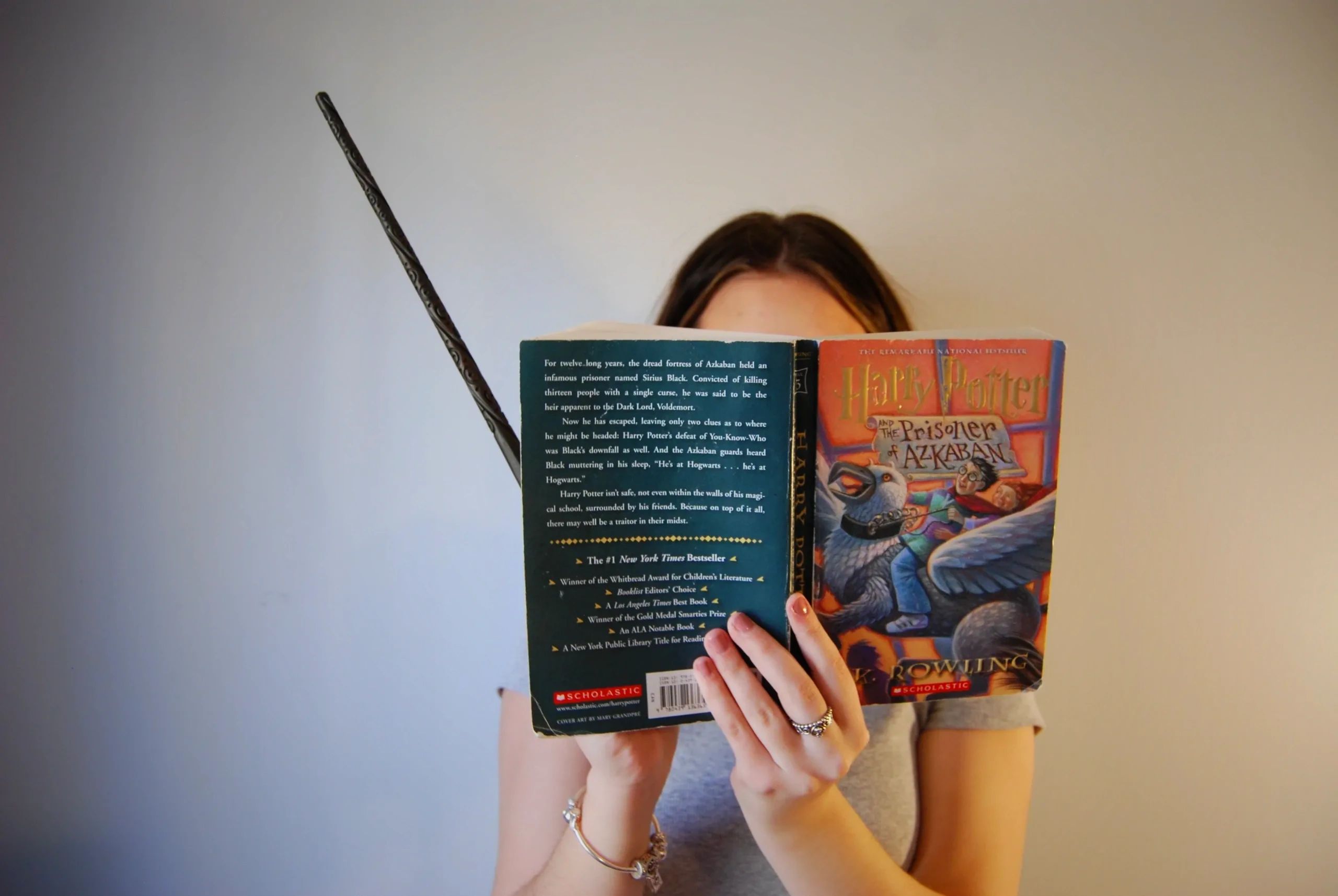 Self portrait holding a Harry Potter wand and The Prisoner of Azkaban book by J.K. Rowling