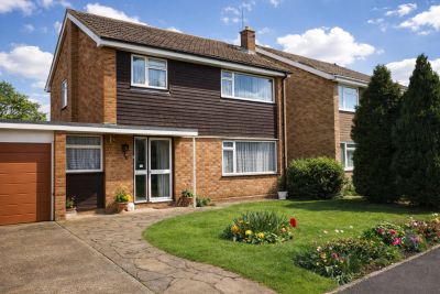 Two-story suburban house with a garden and driveway.