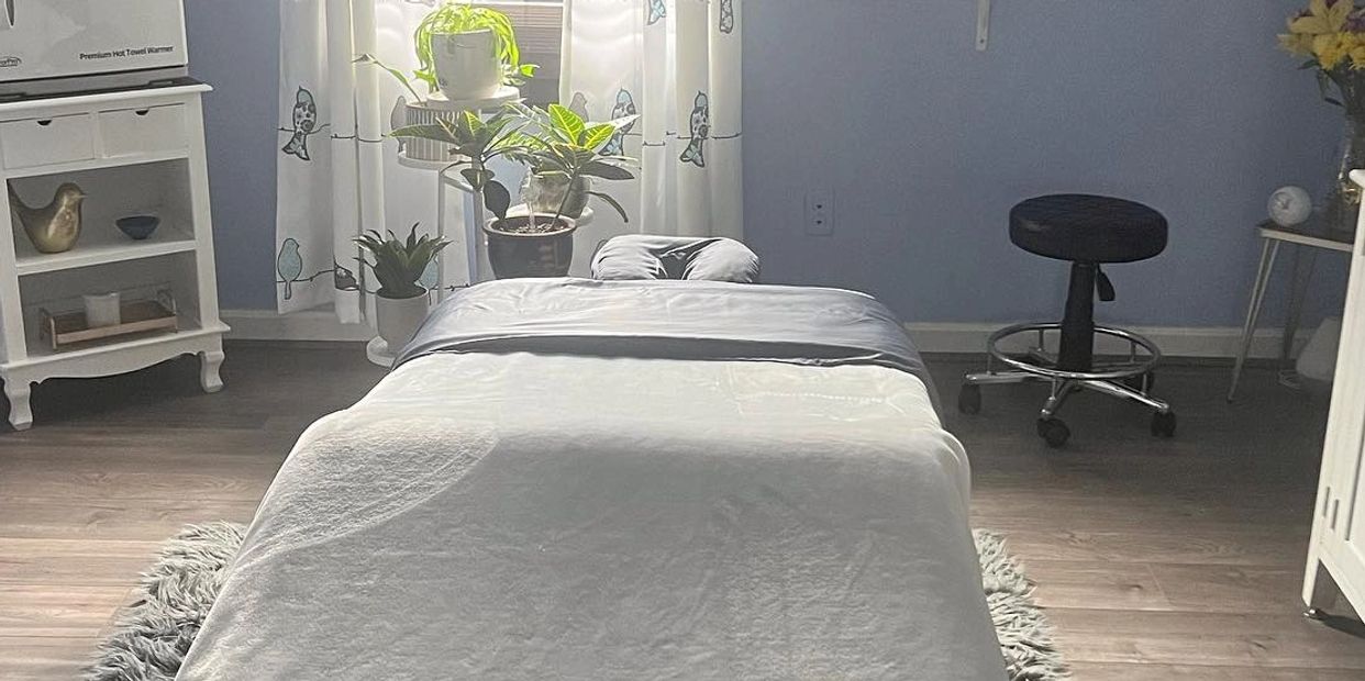 Massage table in a serene room settings, dimly lit with candles.