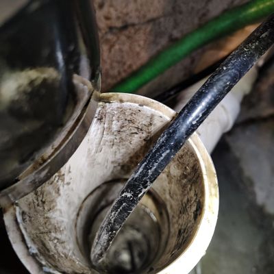 Close-up of a dirty pipe with a black cable inside.