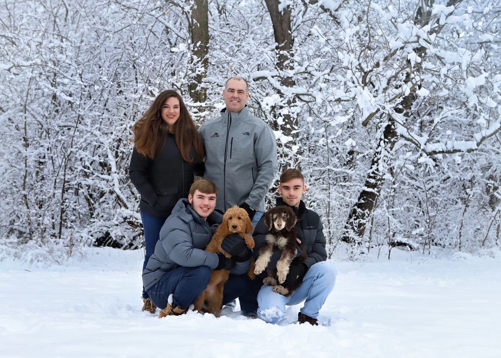 Our family and Holly the Goldendoodle, and Indiana our poodle stud when they were puppies. 