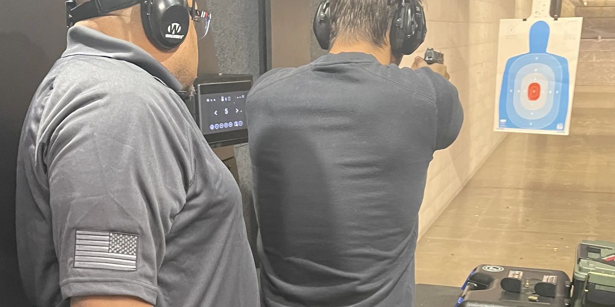 Two men at an indoor shooting range.