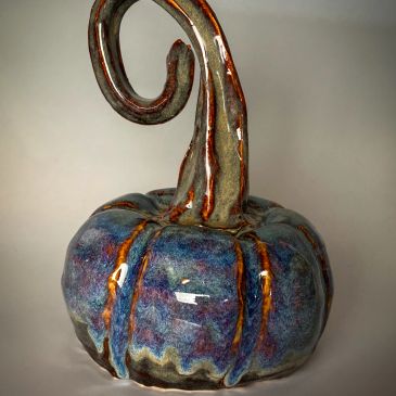 Glazed ceramic pumpkin sculpture with twisty stem.