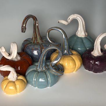Ceramic pumpkins in various colors and shapes.