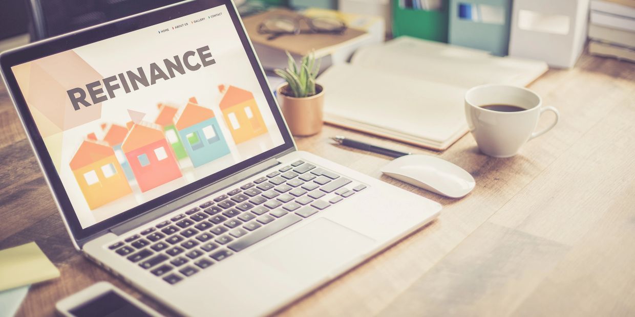 Laptop on desk with refinance graphic on screen.