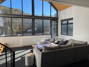 Bright living room with large windows and a cozy sectional sofa.