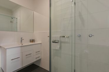 shower, vanity, grey tiles, white tiles, mirror