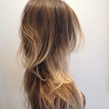 Side view of long, layered highlighted hair.