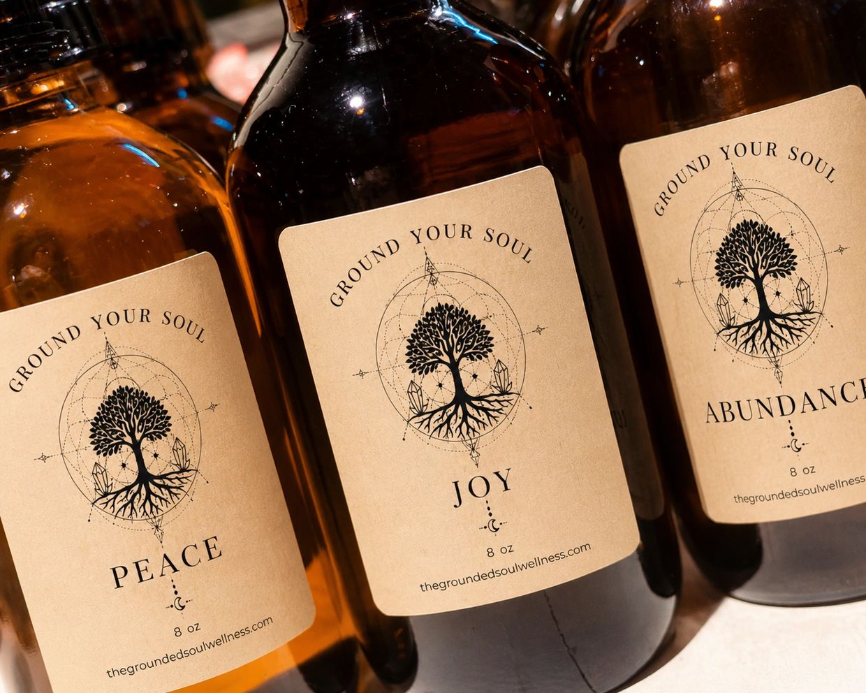 Amber bottles labeled Peace, Joy, and Abundance from The Grounded Soul Wellness.