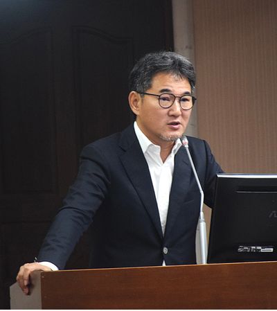 Man in suit speaking at a podium with a microphone.