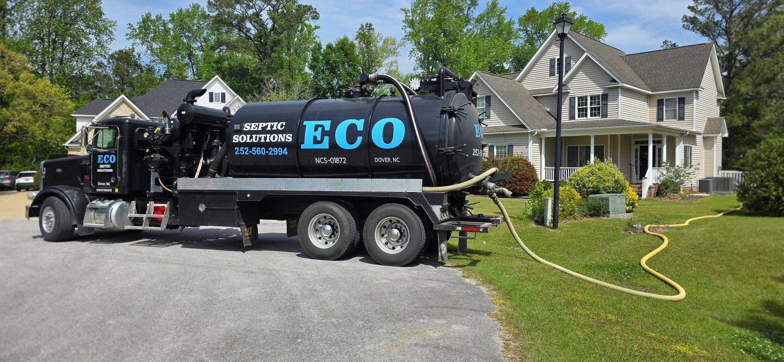 Eco Septic solutions truck parked outside a house on a sunny day.