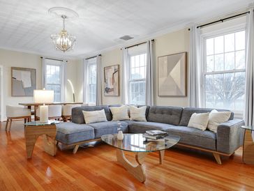 Modern living room with a gray sectional sofa and glass coffee table.