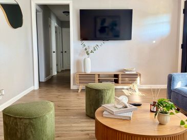 Modern living room with green stools and wooden furniture.