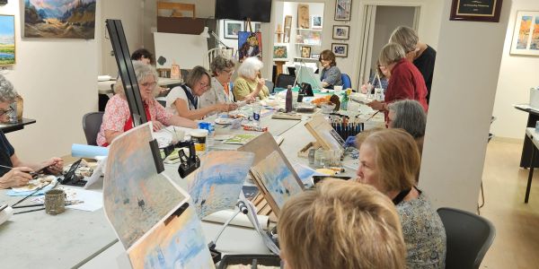Group of seniors painting in art class.