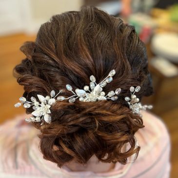 Elegant bridal updo adorned with delicate pearl and crystal hair accessories.