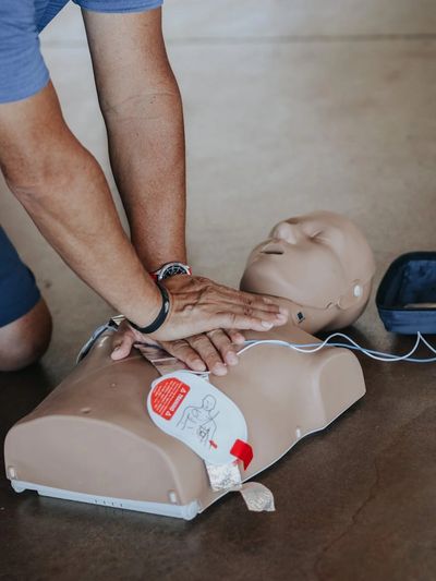 Person practicing CPR on a training mannequin.