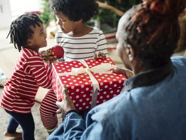 Children receiving a gift from an elder.