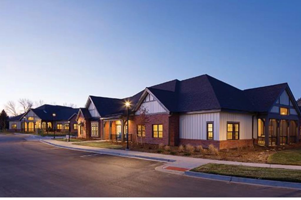 Modern suburban houses with warm lights at dusk.