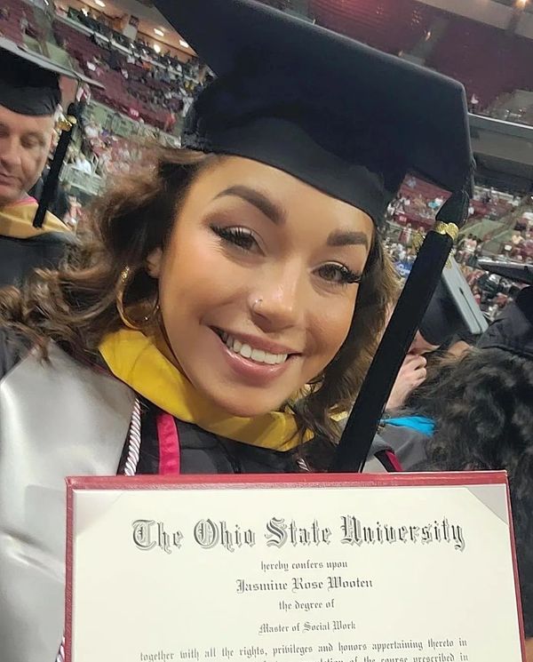 I was holding up my Diploma with excitement at the Graduation ceremony.