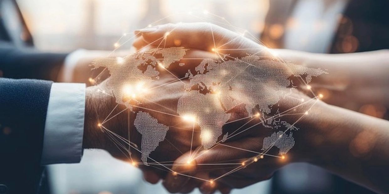 Two hands holding with digital world map overlay.