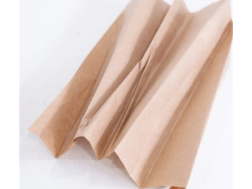 A crumpled brown paper bag on a white surface.