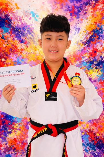 Young Taekwondo champion proudly holding medal and certificate.