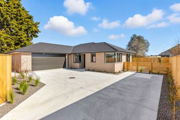Modern single-story brick house with a spacious driveway and double garage.