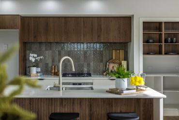 Modern kitchen with wooden cabinetry and a white island countertop.