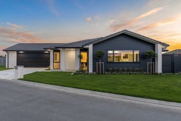 Modern single-story house with a sleek gray exterior at sunset.
