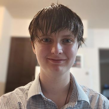 Young person with wet hair smiling indoors.