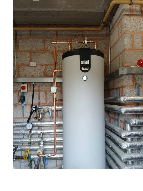 Tall white water heater with copper piping in utility room.