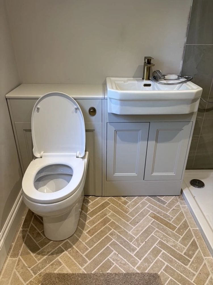 Clean and modern bathroom with toilet, sink, and shower.