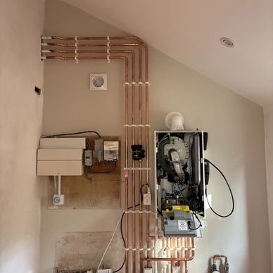Neatly installed copper pipes for a heating system on a wall.